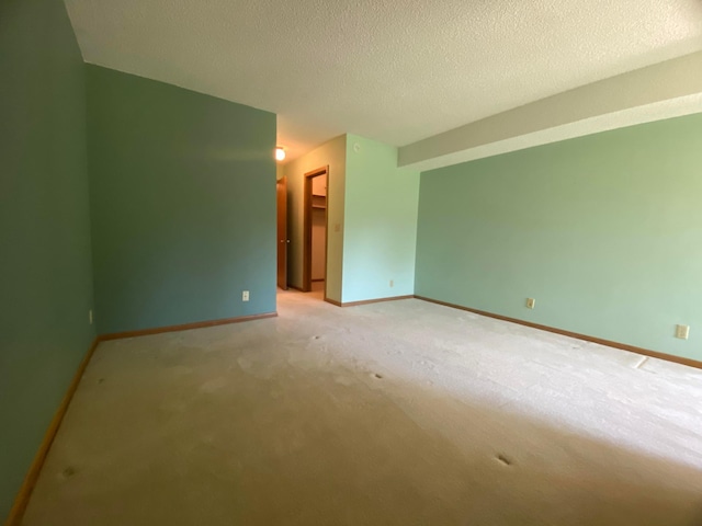 carpeted spare room with a textured ceiling