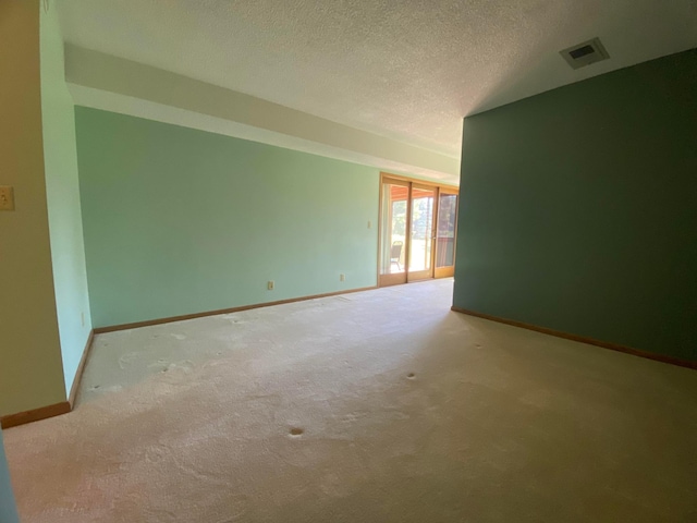 carpeted spare room featuring a textured ceiling