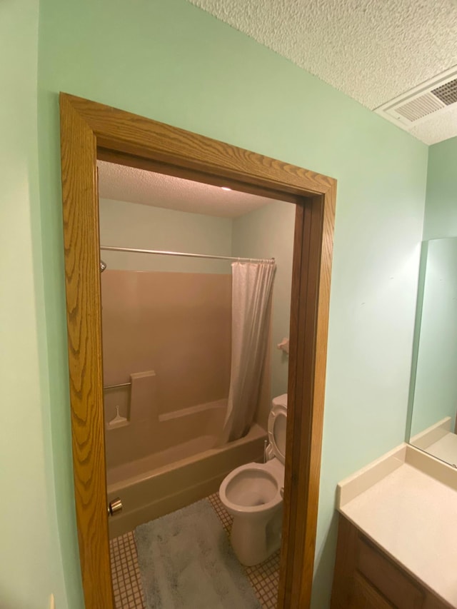 full bathroom with shower / tub combo, tile patterned floors, toilet, and a textured ceiling