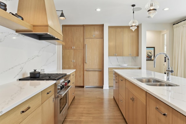 kitchen with tasteful backsplash, sink, light hardwood / wood-style floors, washer / clothes dryer, and high end stove