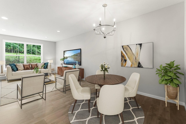 dining room with hardwood / wood-style floors and a chandelier