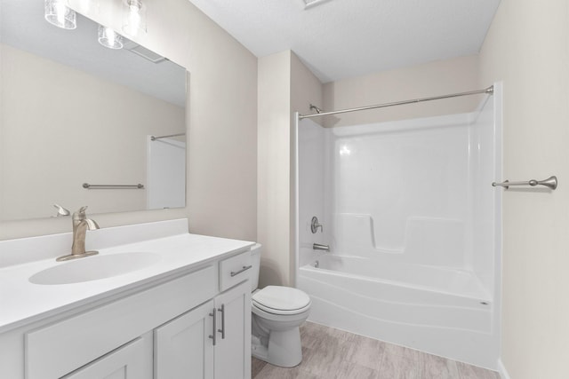 full bathroom featuring vanity, toilet, washtub / shower combination, and a textured ceiling