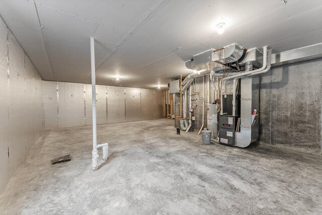 basement featuring heating unit and water heater