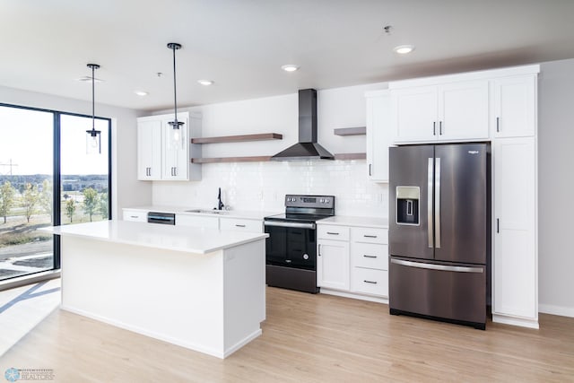 kitchen with white cabinets, wall chimney exhaust hood, decorative light fixtures, stainless steel appliances, and a center island