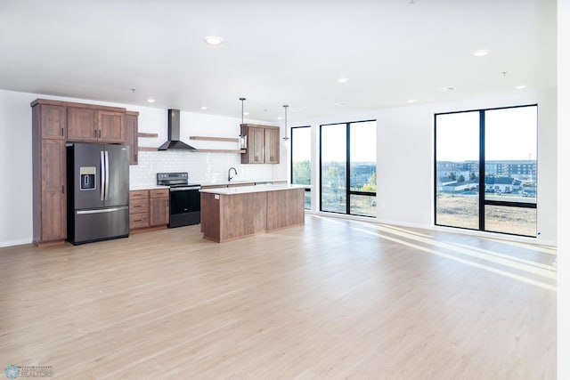 kitchen with hanging light fixtures, stainless steel refrigerator with ice dispenser, electric range, and plenty of natural light