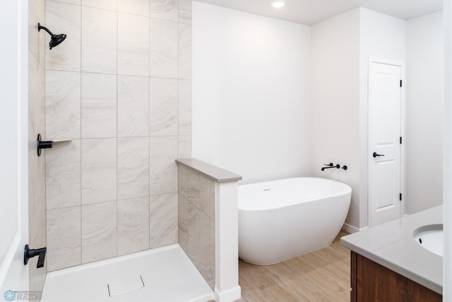 bathroom with independent shower and bath, vanity, and wood-type flooring