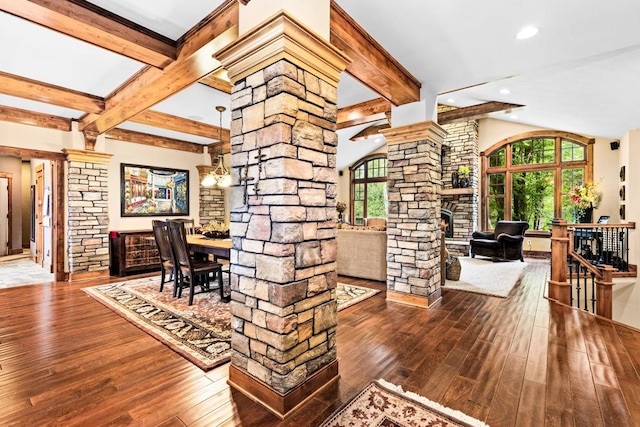dining space featuring beamed ceiling, wood-type flooring, and decorative columns