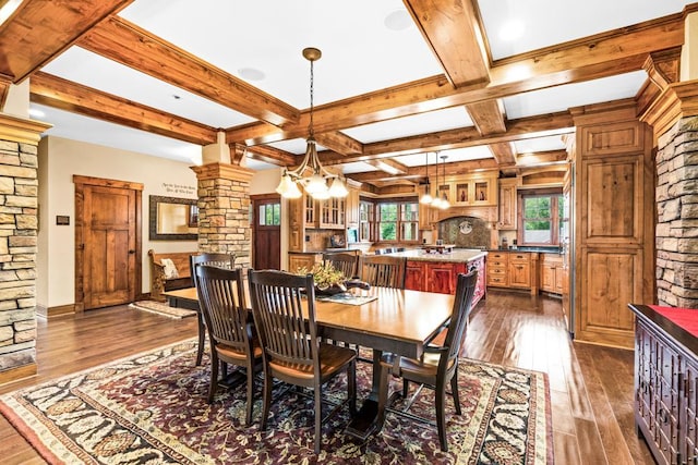 dining area with an inviting chandelier, dark wood finished floors, decorative columns, beamed ceiling, and coffered ceiling