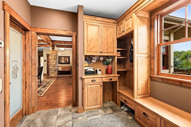 mudroom featuring stone finish floor and beam ceiling