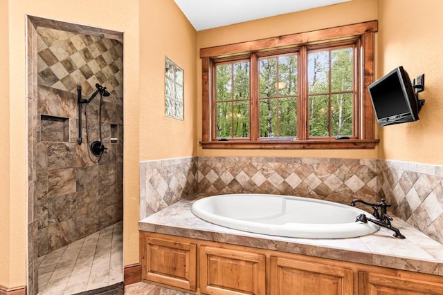 full bathroom featuring a bath and tiled shower