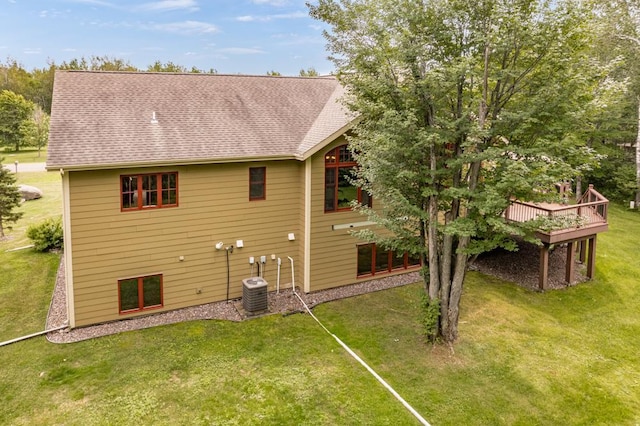 back of house featuring a lawn, a shingled roof, central air condition unit, and a wooden deck