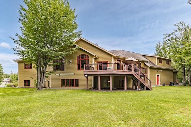rear view of house featuring a yard, a deck, and stairs