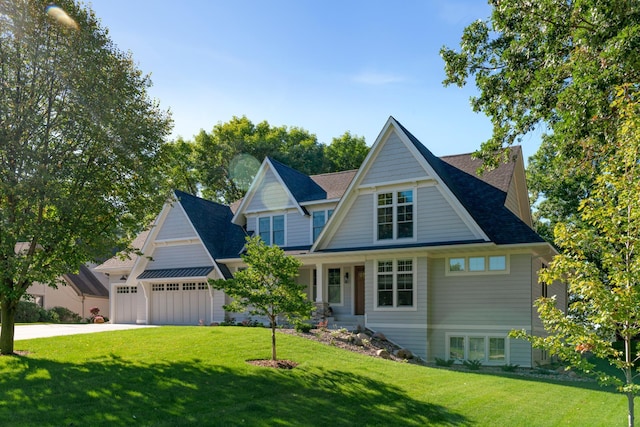 craftsman house featuring a garage and a front lawn