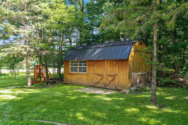 view of outbuilding featuring a playground and a lawn