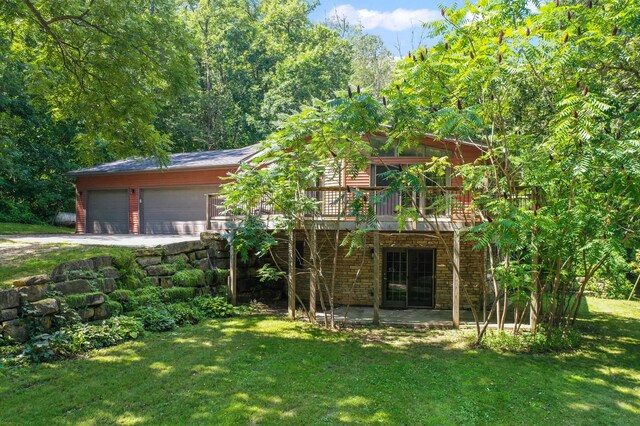 exterior space with a wooden deck, a garage, and a front lawn