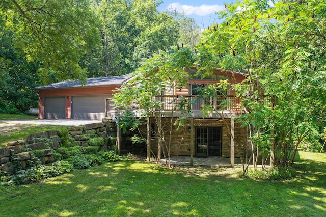 exterior space with a garage, a patio, stone siding, a deck, and a front lawn