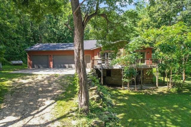 view of front of house featuring driveway, a wooden deck, a garage, and a front yard