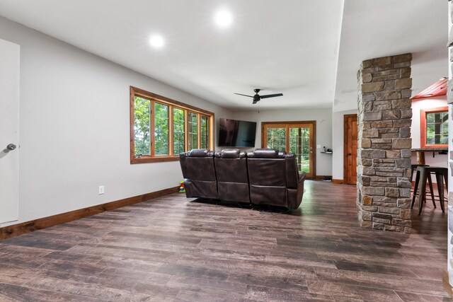 living room featuring ornate columns, dark hardwood / wood-style floors, and ceiling fan