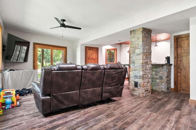 living area featuring wood finished floors, a ceiling fan, and ornate columns