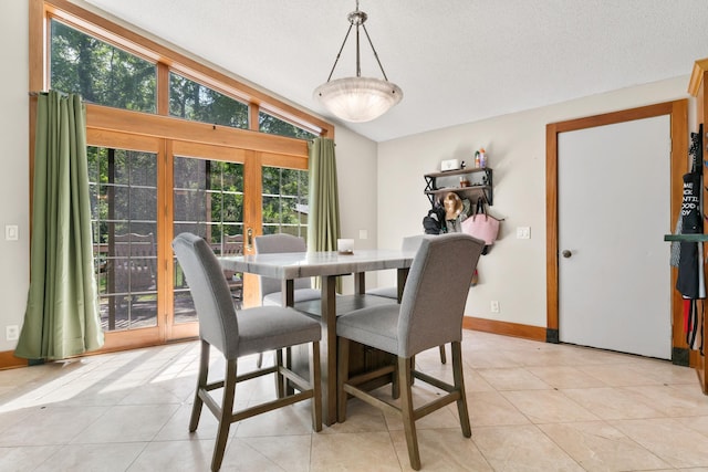 dining area featuring french doors, light tile patterned flooring, a textured ceiling, and lofted ceiling