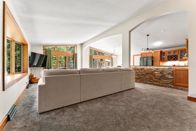 living area featuring carpet floors, lofted ceiling, indoor bar, and a textured ceiling