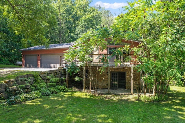 exterior space featuring a front yard, a patio area, a deck, stone siding, and a forest view