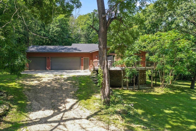 view of front of home with driveway, an attached garage, a wooden deck, and a front yard