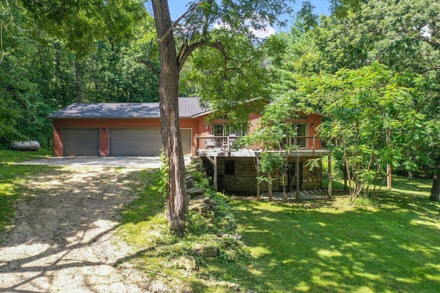 view of front of home featuring driveway, a wooden deck, an attached garage, and a front yard