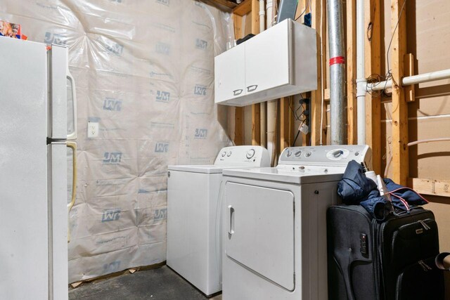 washroom featuring cabinets and washing machine and clothes dryer