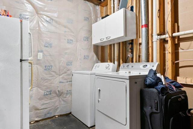 washroom featuring washing machine and clothes dryer and cabinet space