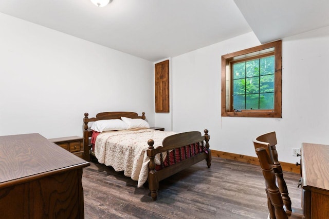 bedroom with dark wood-style floors and baseboards