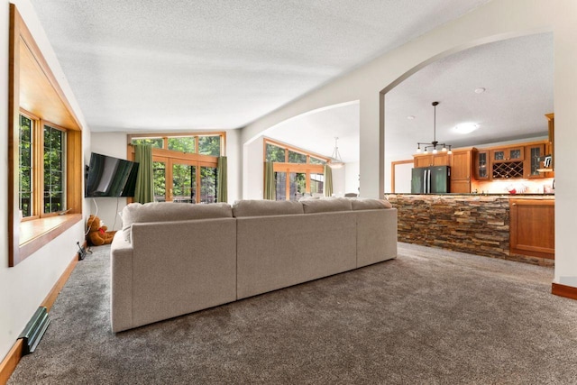 living area featuring carpet, bar area, vaulted ceiling, and a textured ceiling