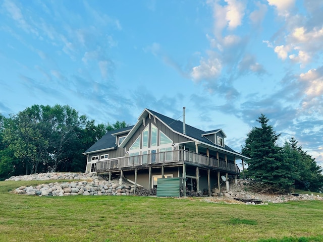 back of house featuring a lawn and a deck