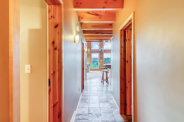 hall featuring beamed ceiling and light tile patterned floors