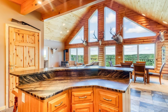 kitchen featuring dark stone countertops, high vaulted ceiling, beamed ceiling, and wood ceiling