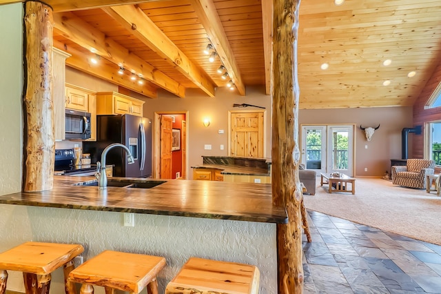 kitchen with beamed ceiling, carpet flooring, sink, wooden ceiling, and light brown cabinets