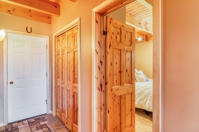 hall featuring beam ceiling and tile patterned floors