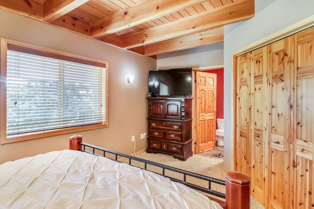 carpeted bedroom featuring beamed ceiling, ensuite bathroom, and wood ceiling