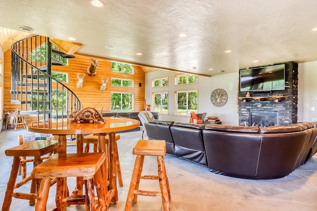 living room with a fireplace, wooden walls, and a textured ceiling