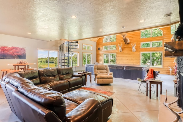 living room with wood walls, a fireplace, and a textured ceiling