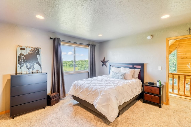 bedroom featuring light carpet and a textured ceiling