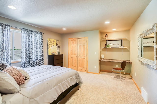 carpeted bedroom featuring a textured ceiling and a closet