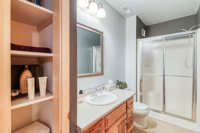 bathroom with an enclosed shower, vanity, and toilet