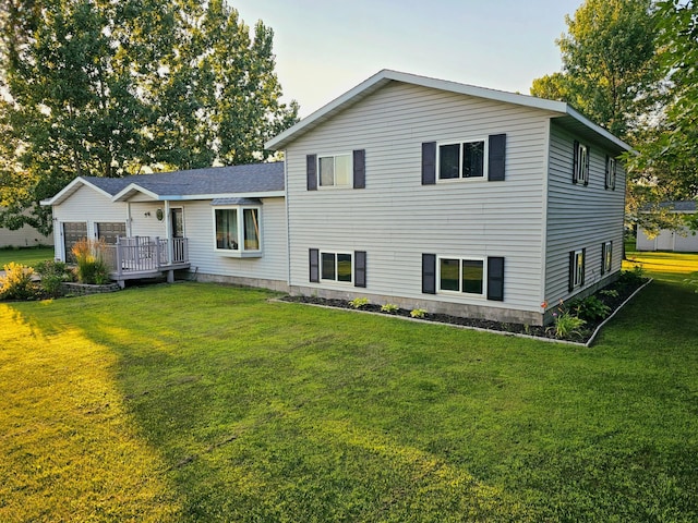 back of property with a lawn and a wooden deck