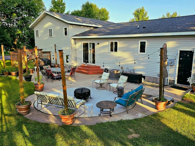 back of property featuring a lawn, central AC, a patio area, and an outdoor fire pit