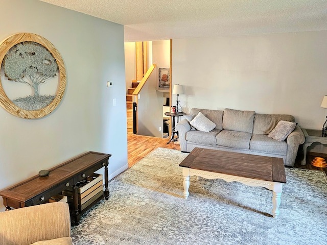 living room featuring wood-type flooring and a textured ceiling