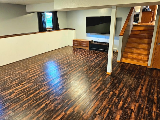 basement featuring a textured ceiling and dark hardwood / wood-style flooring