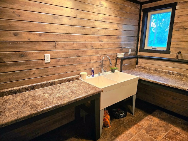 bathroom featuring wooden walls and sink