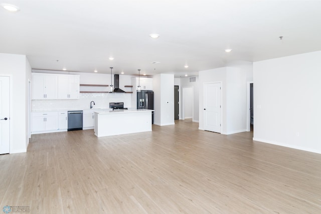 unfurnished living room featuring sink and light hardwood / wood-style floors