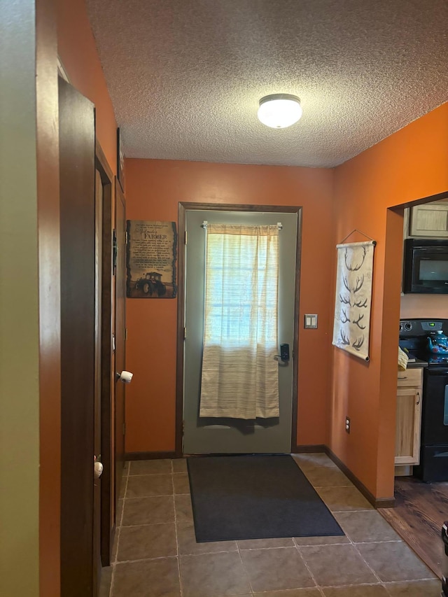 doorway featuring dark tile patterned flooring and a textured ceiling